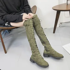 Vue détaillée des bottes au-dessus du genou vert olive avec lacets et fermeture éclair.