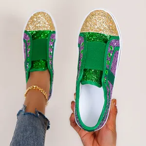Close-up detail of women's sparkling green and purple glitter loafers