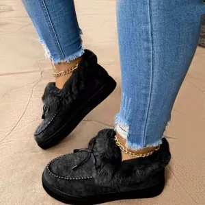 Close-up of women's black plush-lined winter loafers with thick soles and bow details