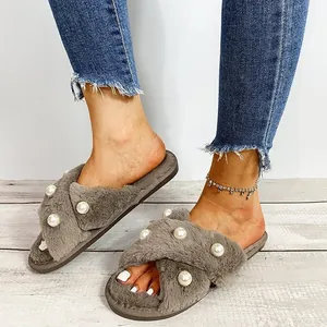 Nahaufnahme grauer Kunstpelz-Kreuzbandschlappen mit eleganten Perlen für Damen.