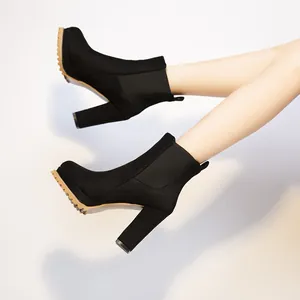 Eleganti stivaletti neri da donna con tacco largo e plateau, punta tonda e pannello elastico.