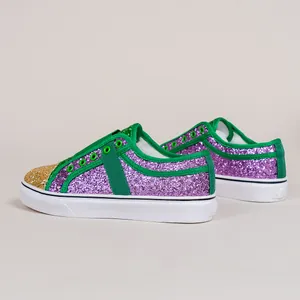 Detail view showing the vibrant purple glitter finish and green fabric straps on loafers