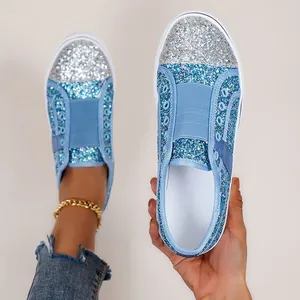 Detailed view of sparkling light blue and silver sequin loafers with flat white soles