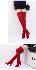 Detail of red suede over-the-knee boots with pointed toe and chunky high heel