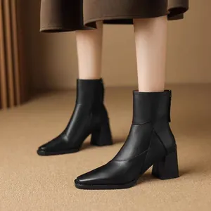 Side view detail of elegant black pointed toe ankle boots with chunky heels and back zipper
