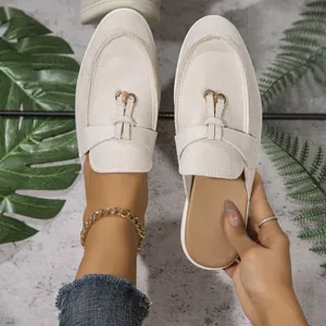 Vue détaillée des mules en daim beige à bout pointu avec boucle dorée élégante