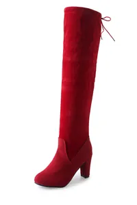 Detail shot of elegant red suede over-the-knee boots featuring a chunky high heel.
