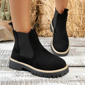 Detalle de botines Chelsea de ante negro con suela de goma gruesa y elástico lateral