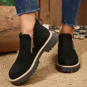 Gros plan de bottines en daim noir avec fermeture éclair latérale et semelle crantée