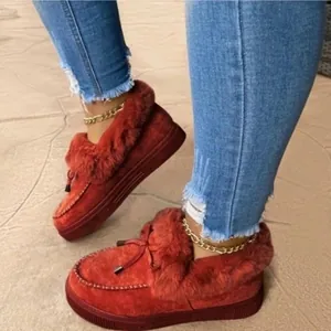 Detailed close-up of red platform winter loafers with warm faux fur lining and decorative bow.