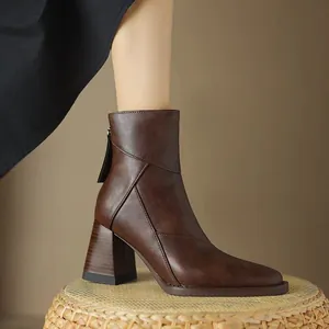 Detailed side view of brown leather pointed toe ankle boots with a chunky block heel