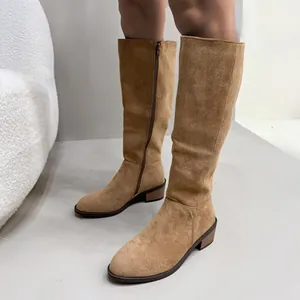 Close-up of stylish tan suede knee-high boots with side zipper and comfortable block heel.