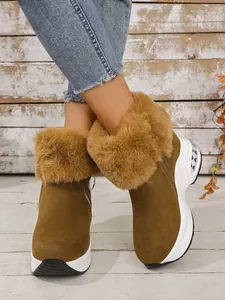 Brown faux fur snow boots with thick white platform soles shown on a model's legs