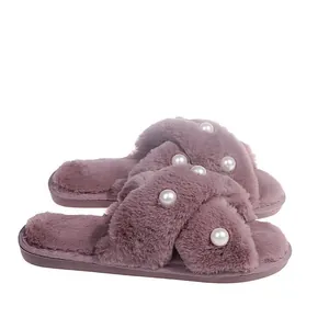 Detailansicht von lila Kunstpelz-Slippern mit Kreuzgurt und Perlenverzierung