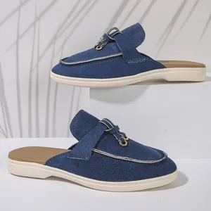 Vue latérale de mules en daim bleu avec une boucle métallique élégante et des coutures
