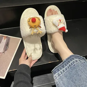 Close-up of cute white plush Christmas slippers with reindeer and Santa Claus decorations.