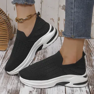 Primer plano de zapatillas negras de malla transpirable fly-knit con suela blanca gruesa