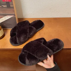 Vista detallada de suaves zapatillas de casa color burdeos con tiras cruzadas de felpa