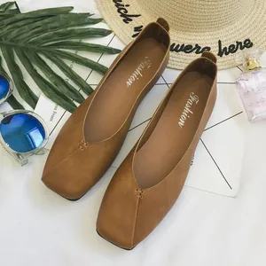 Dettaglio di scarpe basse marroni a punta quadrata con cuciture decorative