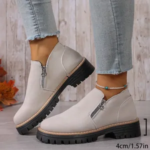 Side profile detail of beige women's ankle boots featuring 4cm lug sole and zipper