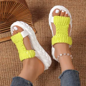 Detail view of women's neon yellow woven platform sandals with chunky white soles.