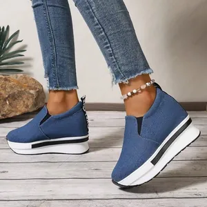 Primer plano de zapatillas de cuña de mezclilla azul con suela de plataforma gruesa
