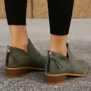 Macro view of women's olive green pointed toe ankle boots with back zipper detail