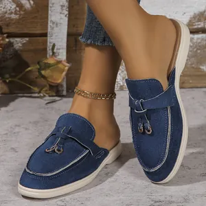 Détail de mocassins en textile bleu marine pour femmes avec anneaux métalliques déco.