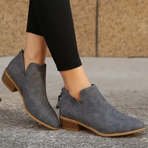 Detailed view of grey pointed-toe Chelsea ankle boots featuring a low chunky heel design