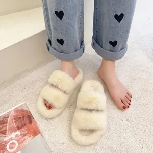 Detailed view of cream faux fur platform slippers worn on feet with heart-patterned jeans.