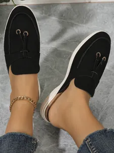 Vue détaillée des mules noires pour femmes en daim avec des œillets métalliques