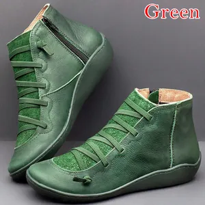 Gros plan détaillé de bottines plates en cuir vert avec fermeture éclair et lacets stylés