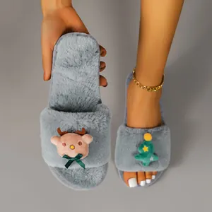Close-up detail of grey fuzzy Christmas slippers with reindeer and tree decorations.
