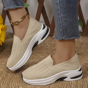 Primer plano de zapatillas beige de malla fly-knit para mujer en un ambiente casual