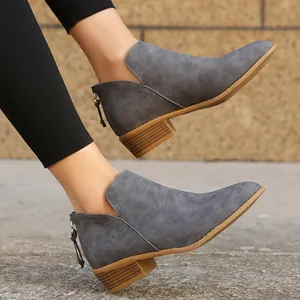 Close-up of grey pointed toe Chelsea ankle boots with chunky heels and side cutouts.