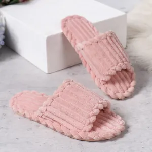 Gros plan de chaussons en velours côtelé rose avec une texture douce et confortable.