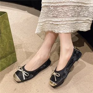 Retro black velvet ballet flats with gold bow and metallic toe cap details.