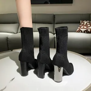 Botines tipo calcetín de punto negro con tacón grueso galvanizado y tejido elástico acanalado.