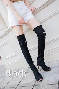 Detailed view of black denim thigh-high peep-toe boots with distressed ripped details