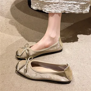 Vintage champagne gold ballet flats featuring a decorative bow and metallic round toe