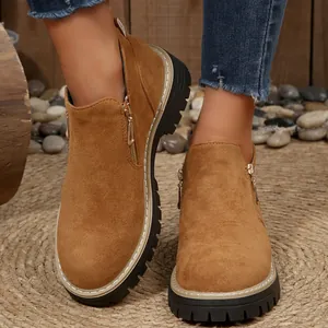 Vue détaillée de bottines en daim marron avec fermeture éclair dorée et semelle crantée