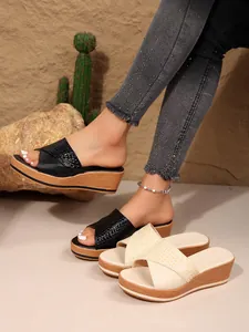 Primer plano de sandalias con cuña y plataforma para mujer con tira cruzada y tacón de madera