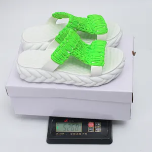 Lightweight neon green woven platform sandals with chunky white soles on an electronic scale