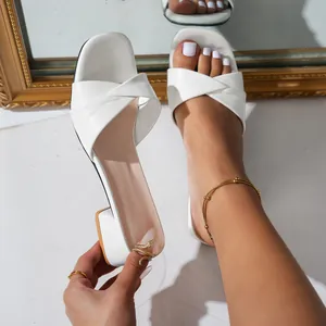 Detalle de elegantes sandalias blancas con tacón bloque y diseño de tira cruzada