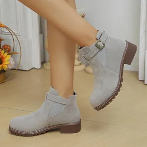 Detailed side view of grey suede ankle boots with side buckle and low block heel