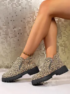 Close-up of leopard print women's boots with chunky black soles and side zippers