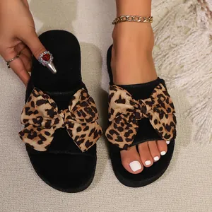 Stylish black suede slippers featuring a bold leopard print bow for outdoor wear.