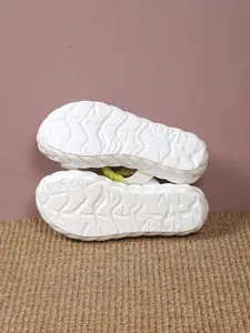 Close-up view of a white non-slip platform sandal outsole with unique textured pattern