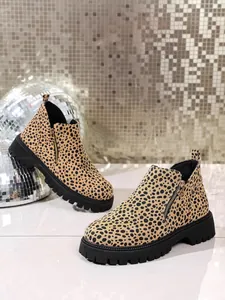 Detailed view of leopard print Chelsea boots with black lug soles and side zippers