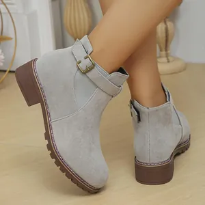 Detailed view of women's grey suede ankle boots with buckle strap and low square heel